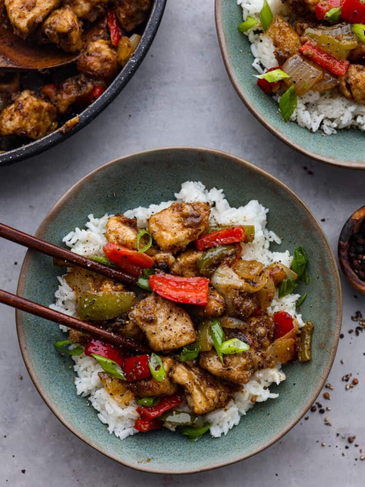 Chicken served over rice in a teal bowl.