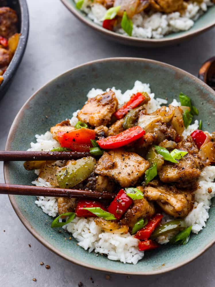 Closeup of black pepper chicken served over white rice.