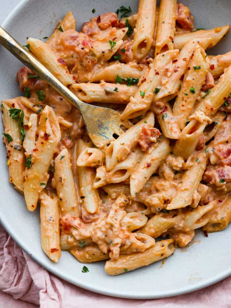 Pink sauce pasta on a plate with a fork. 