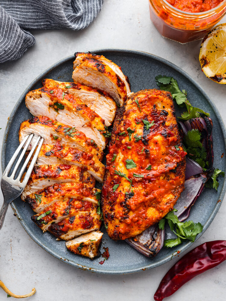 Harissa chicken sliced into pieces.