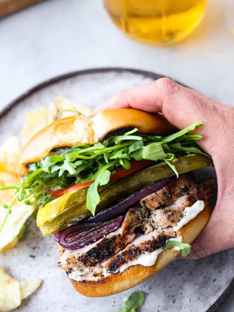 A pork tenderloin sandwich being picked up.