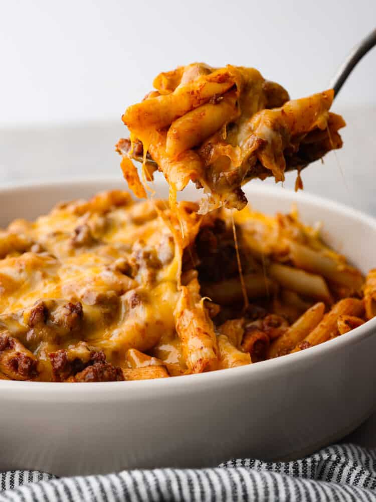 Close side view of sloppy jo casserole being lifted out of the baking dish with a serving spoon.