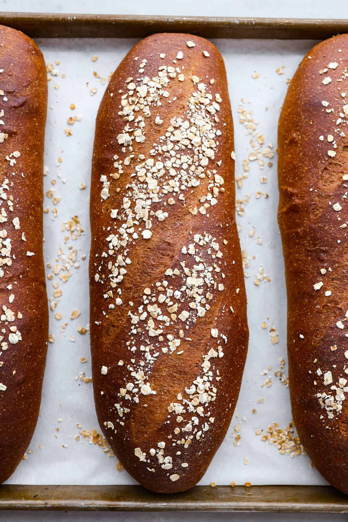 Close overhead view of the bread loaves baked on a baking sheet lined with parchment paper.