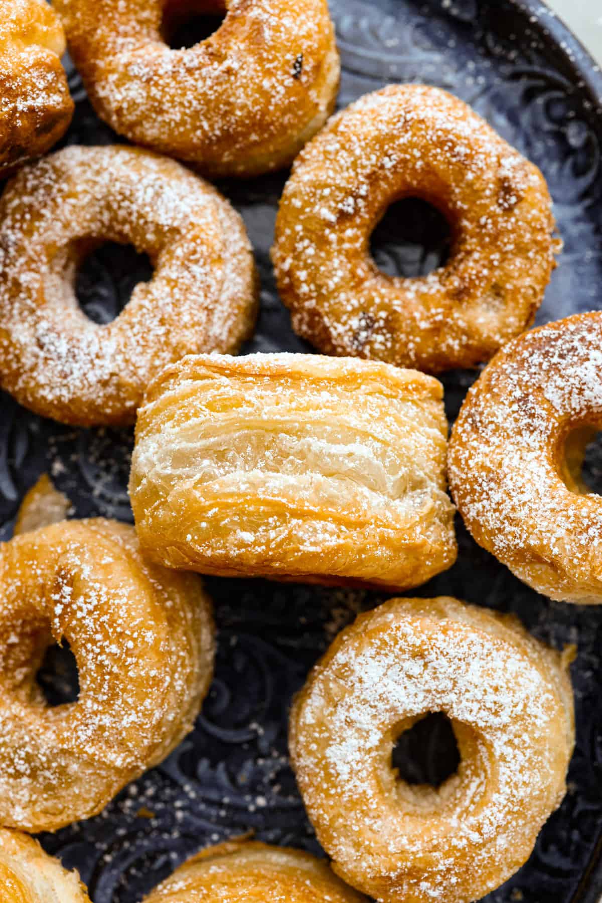 The close up of a cronut on its side so that you can see all of the layers. 