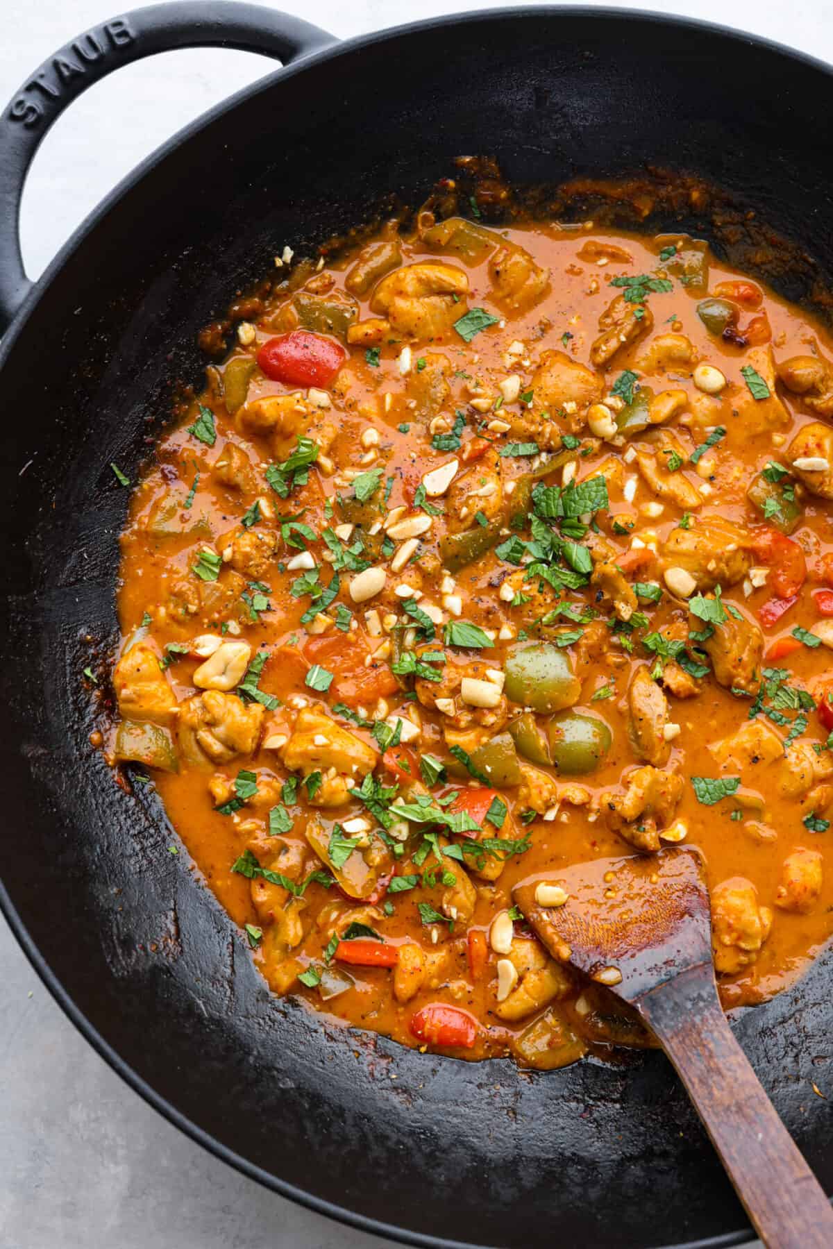 A closeup of cooked parang curry in a wok with a wooden spoon. 