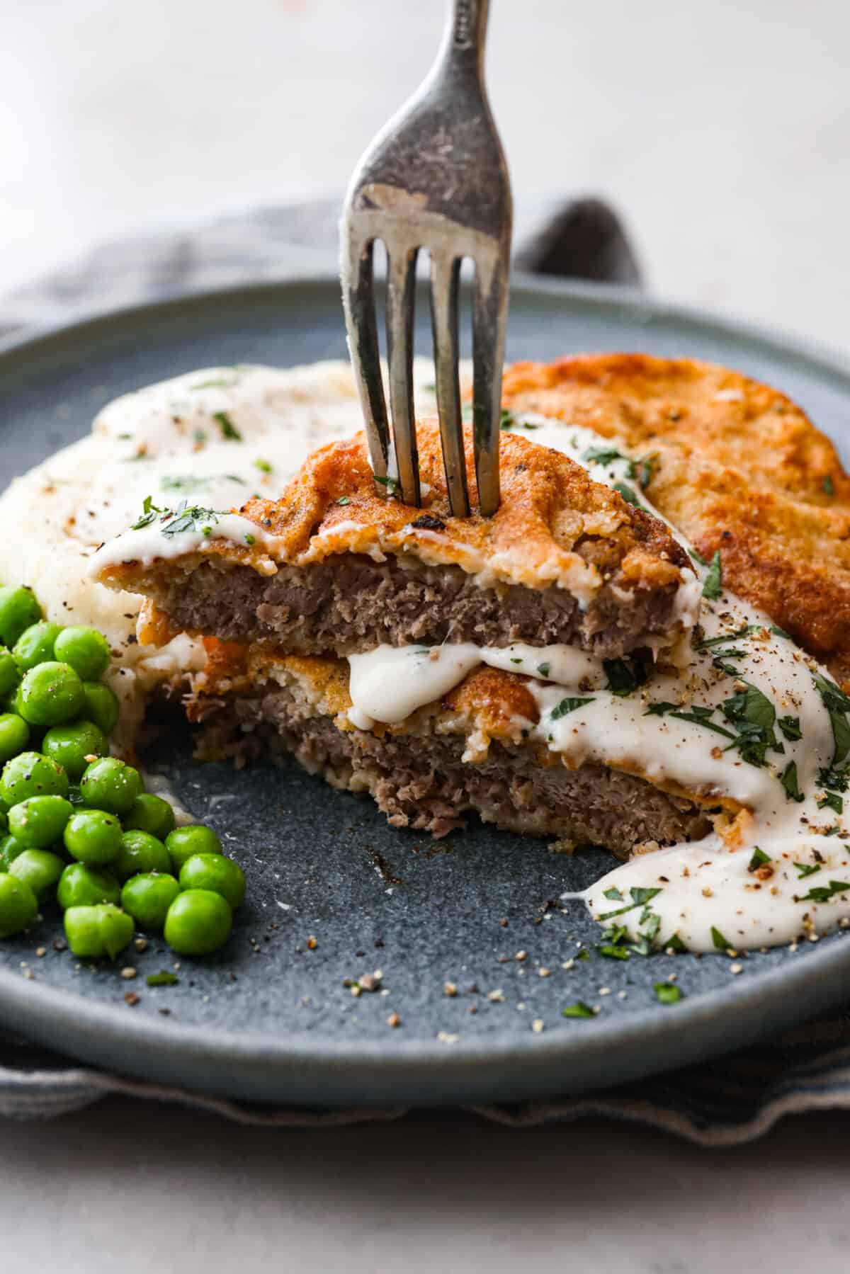 A chicken fried steak that has been cut in half.