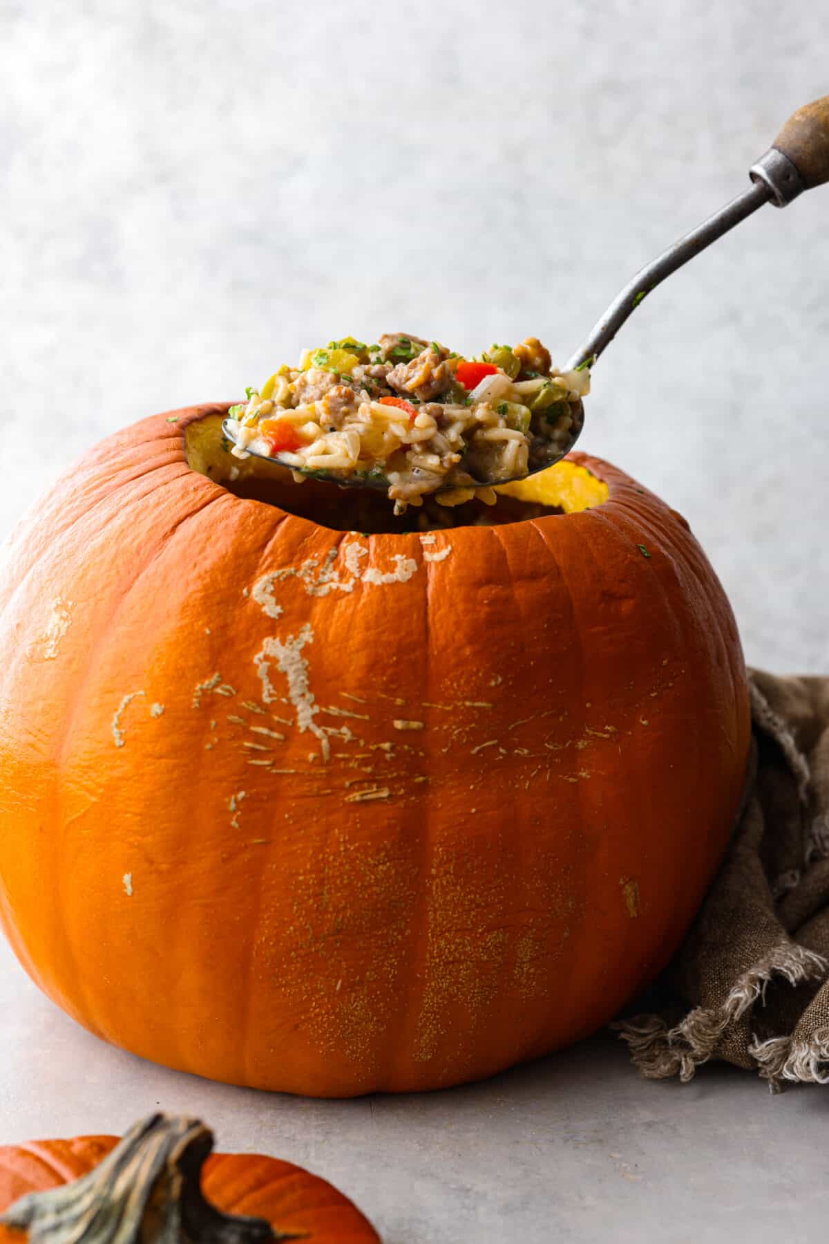 Serving a scoop of dinner in a pumpkin.