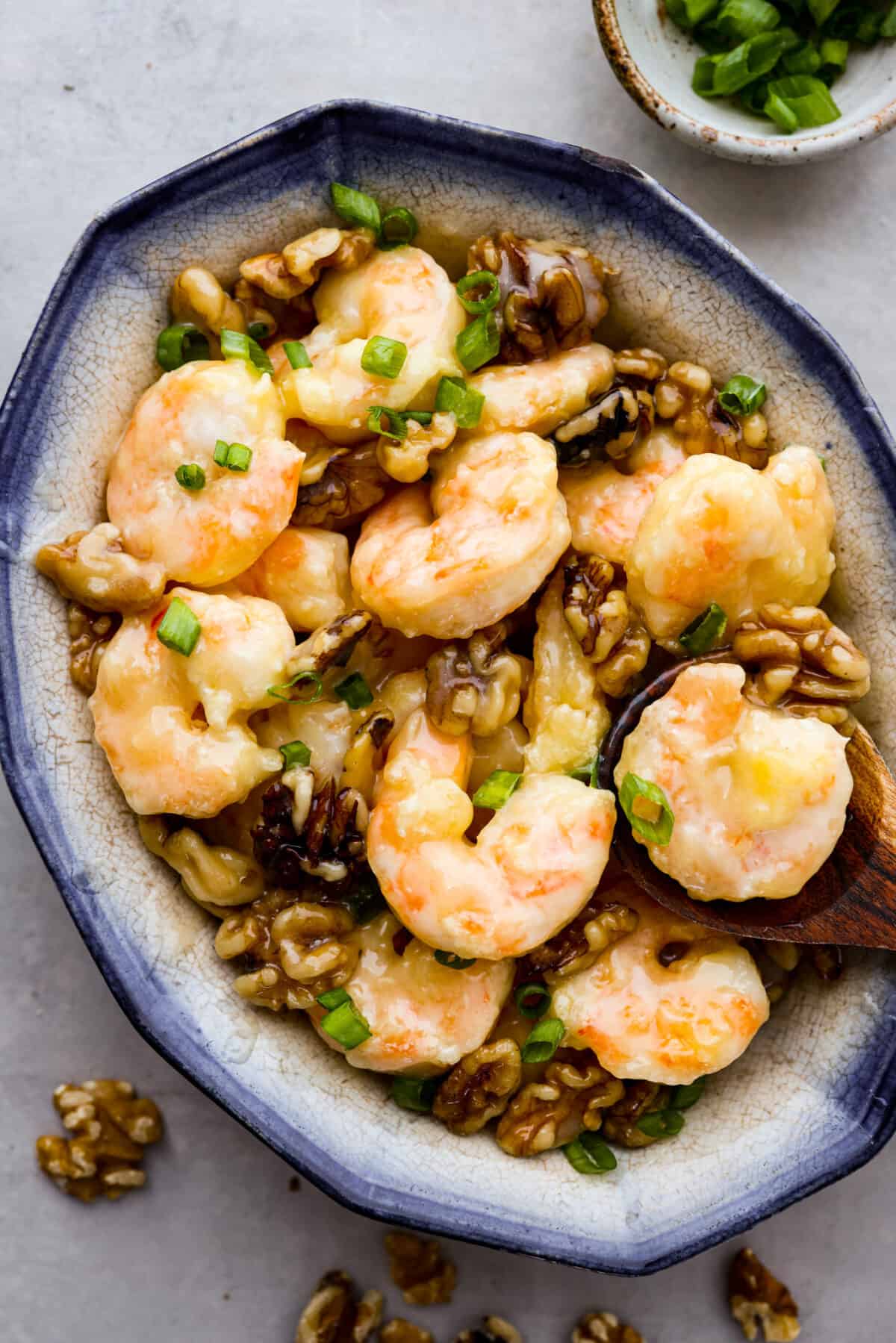 Hero image of crispy walnut shrimp on a blue and white serving dish.