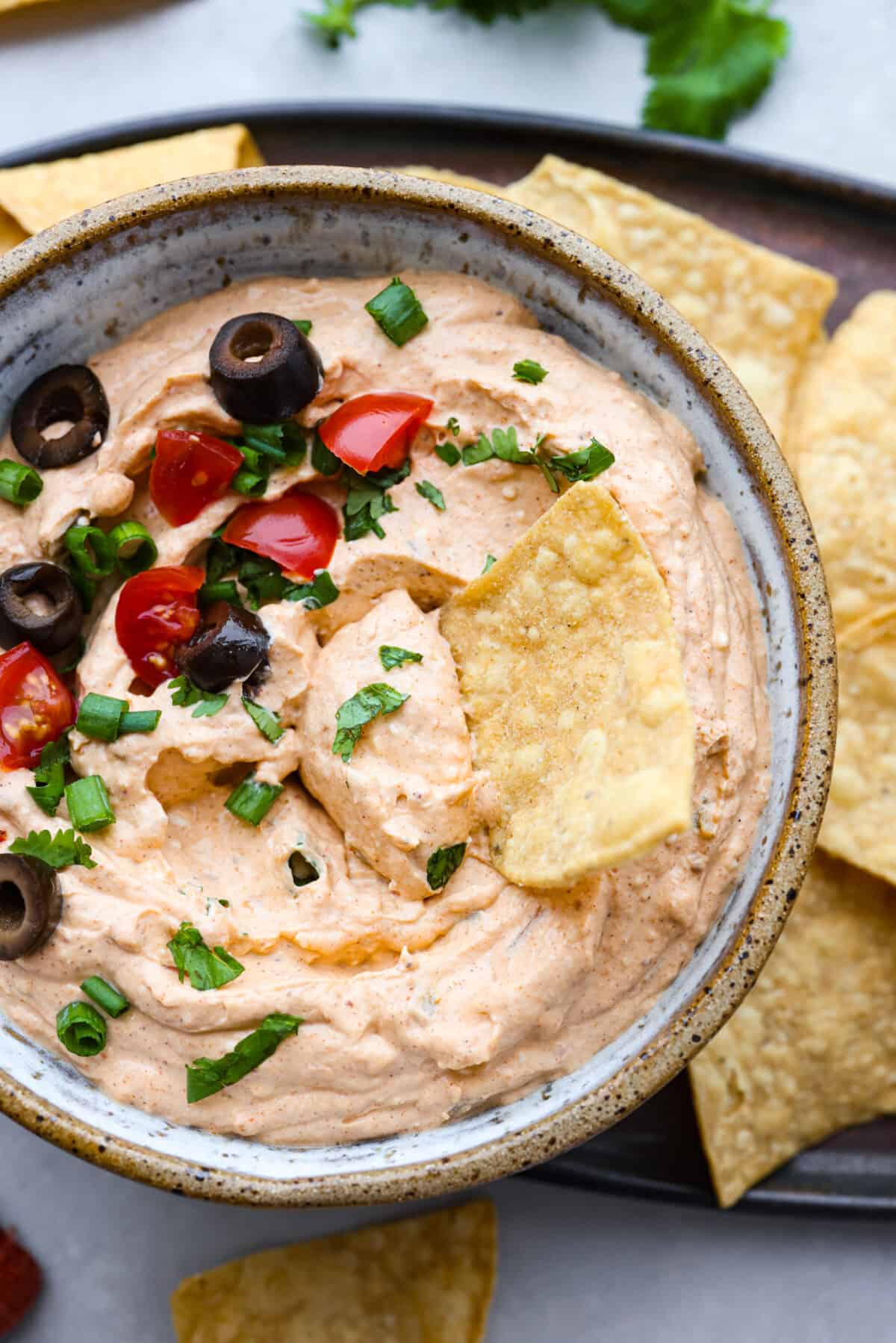 Closeup of taco dip with a tortilla chip in it.