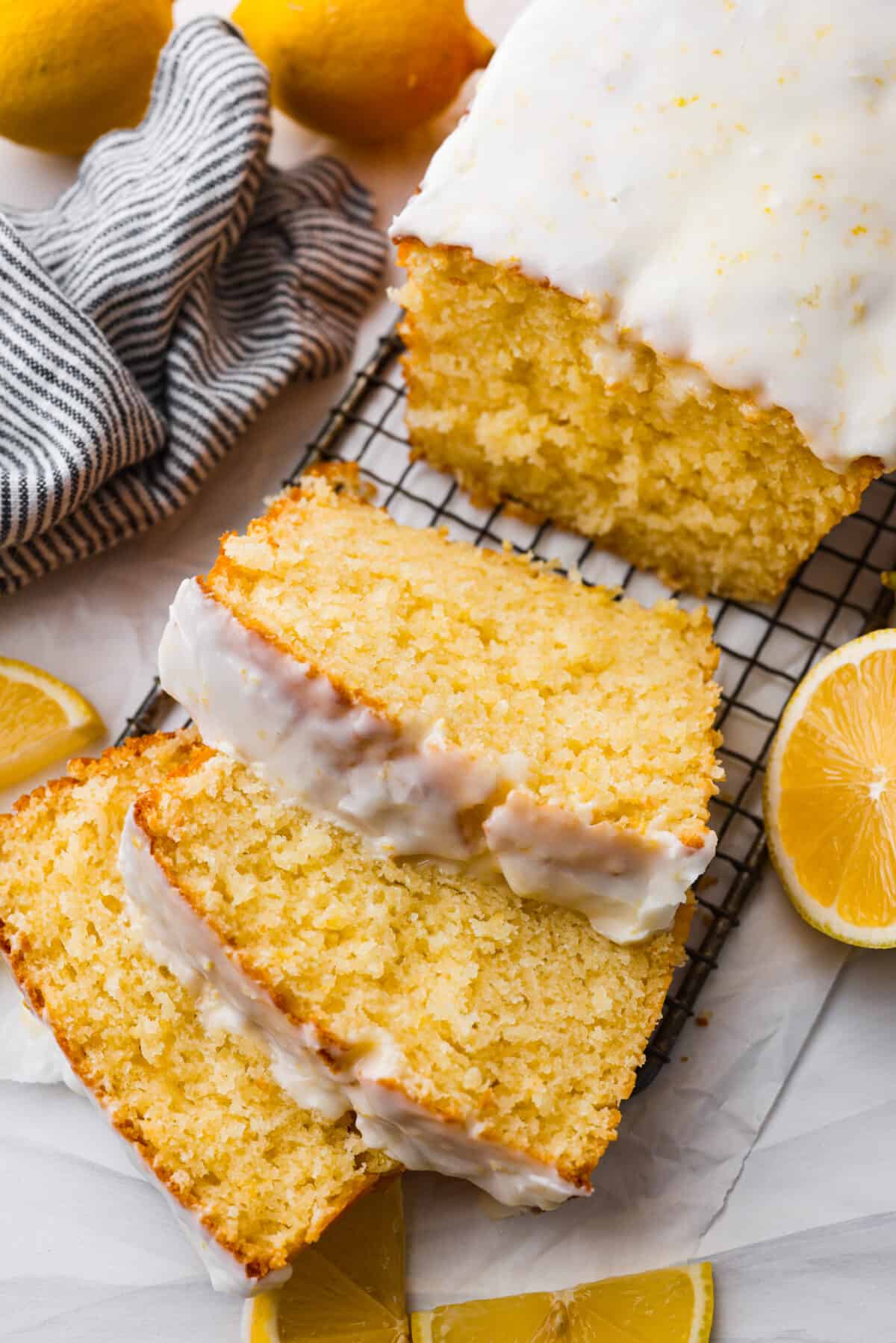 The top view of a lemon loaf on a cooling rack topped with a lemon glaze and sliced. 