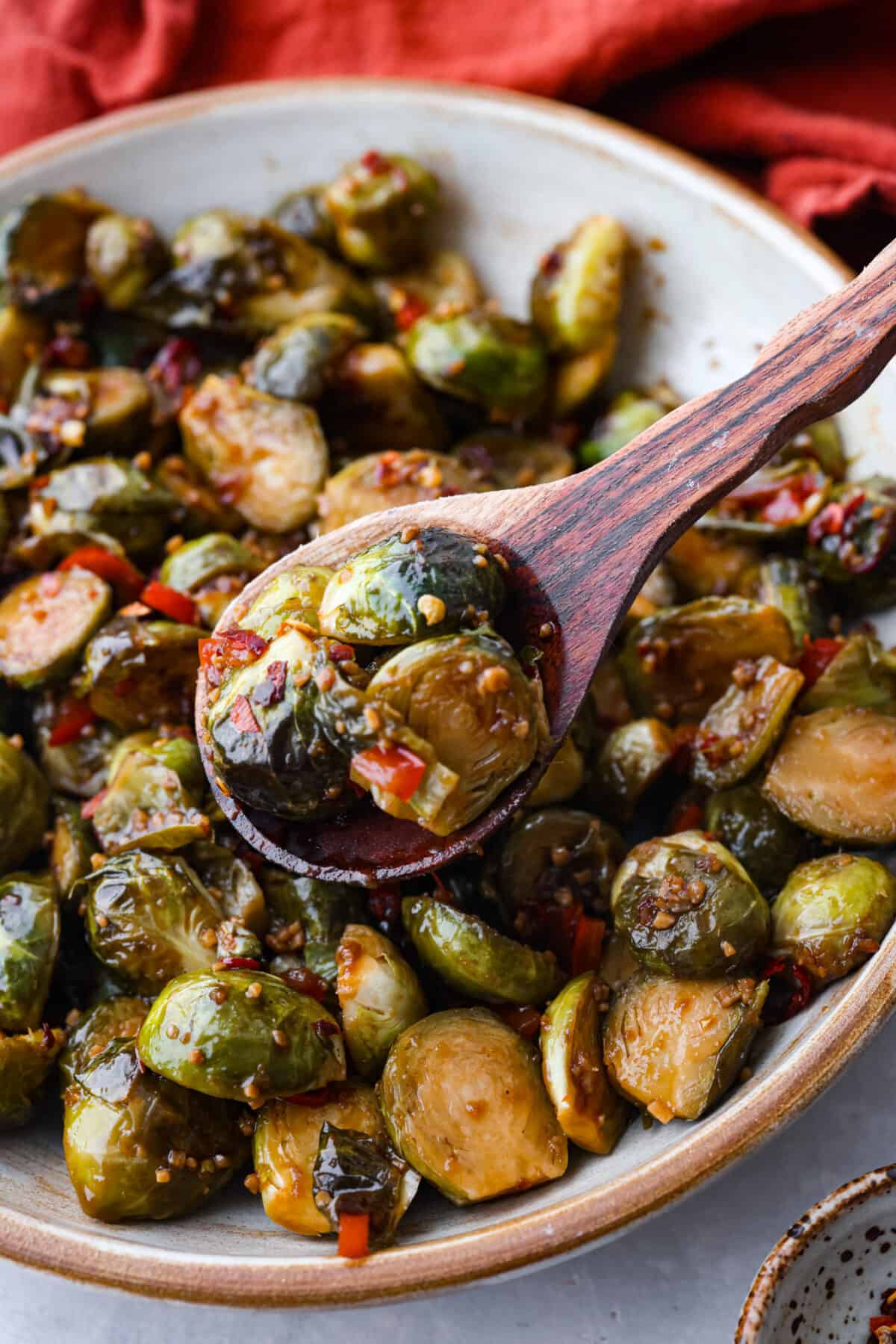 Sprouts being scooped up in a wooden spoon.