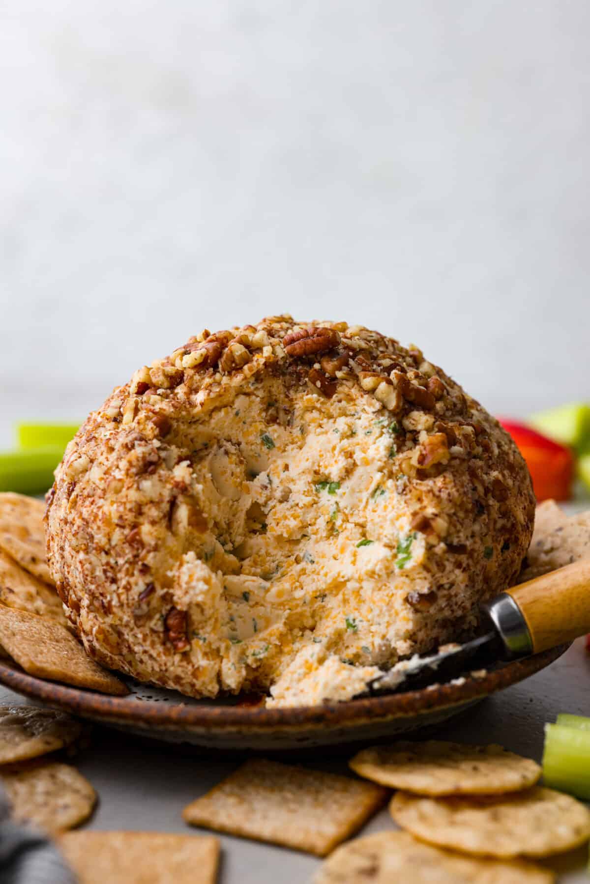 A classic cheese ball, cut into so the cheese inside can be seen.