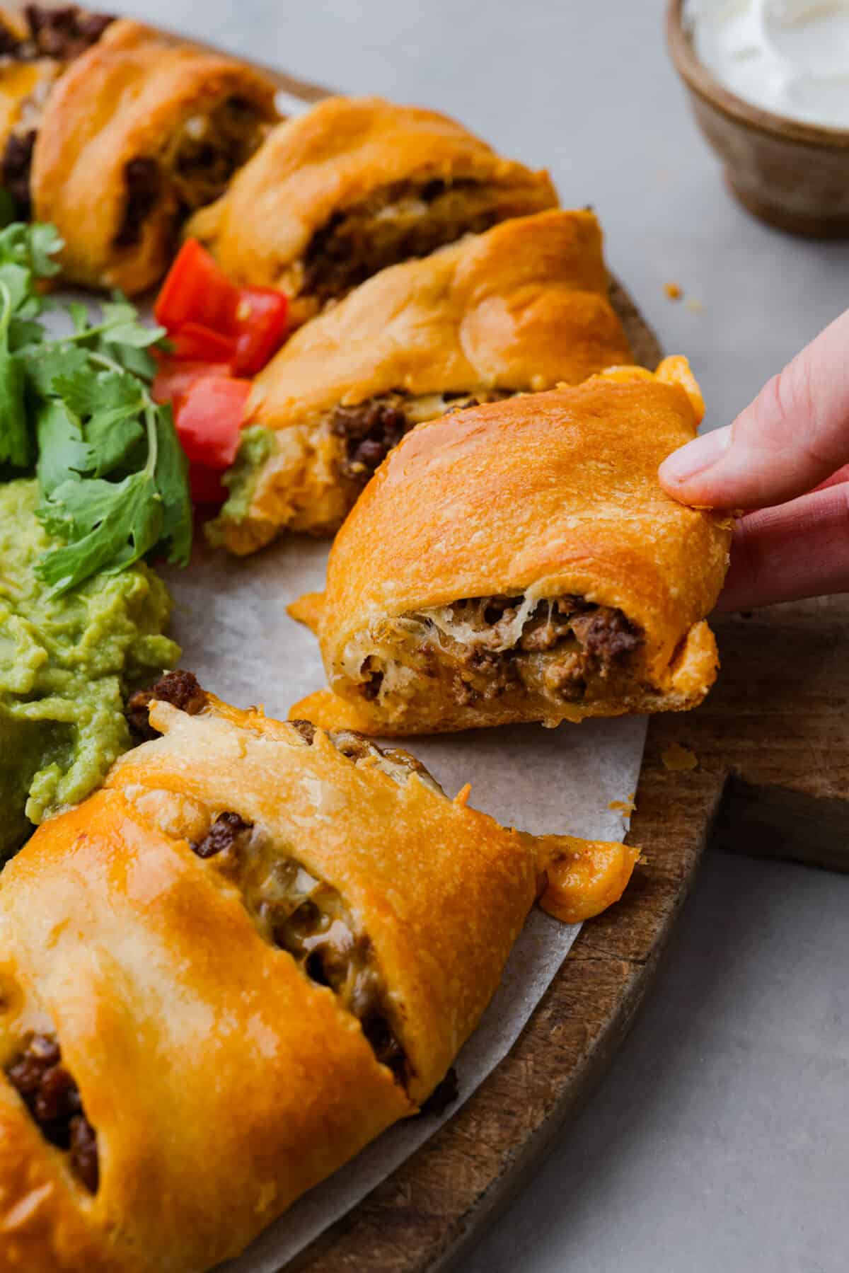 Closeup of crescent roll dough filled with melted colby jack cheese and ground beef.