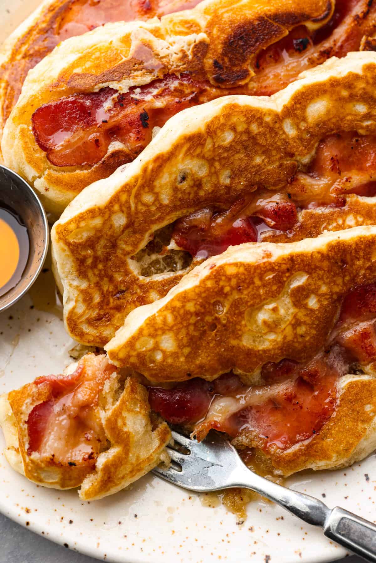 Closeup of a bite of a bacon pancake.