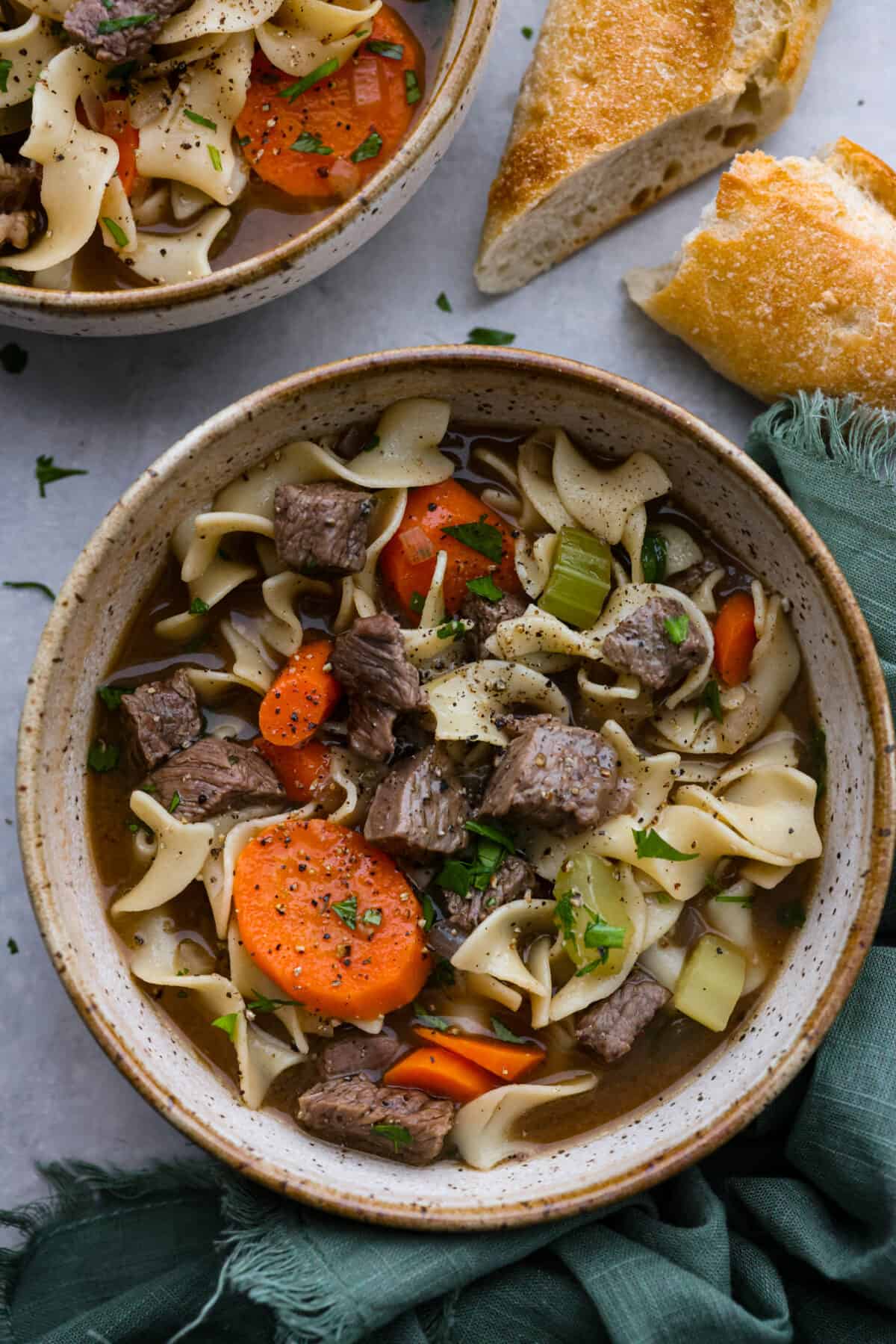 Top-down view of beef noodle soup in a stoneware bowl.