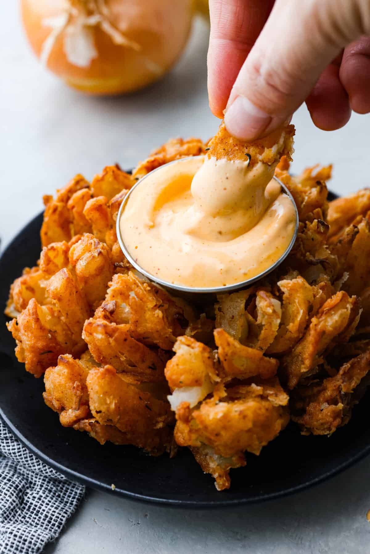 Dipping a piece of onion into a creamy sauce.