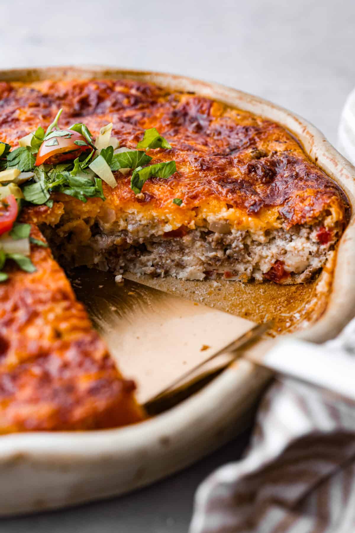 Close view of cheeseburger pie in a pie dish.