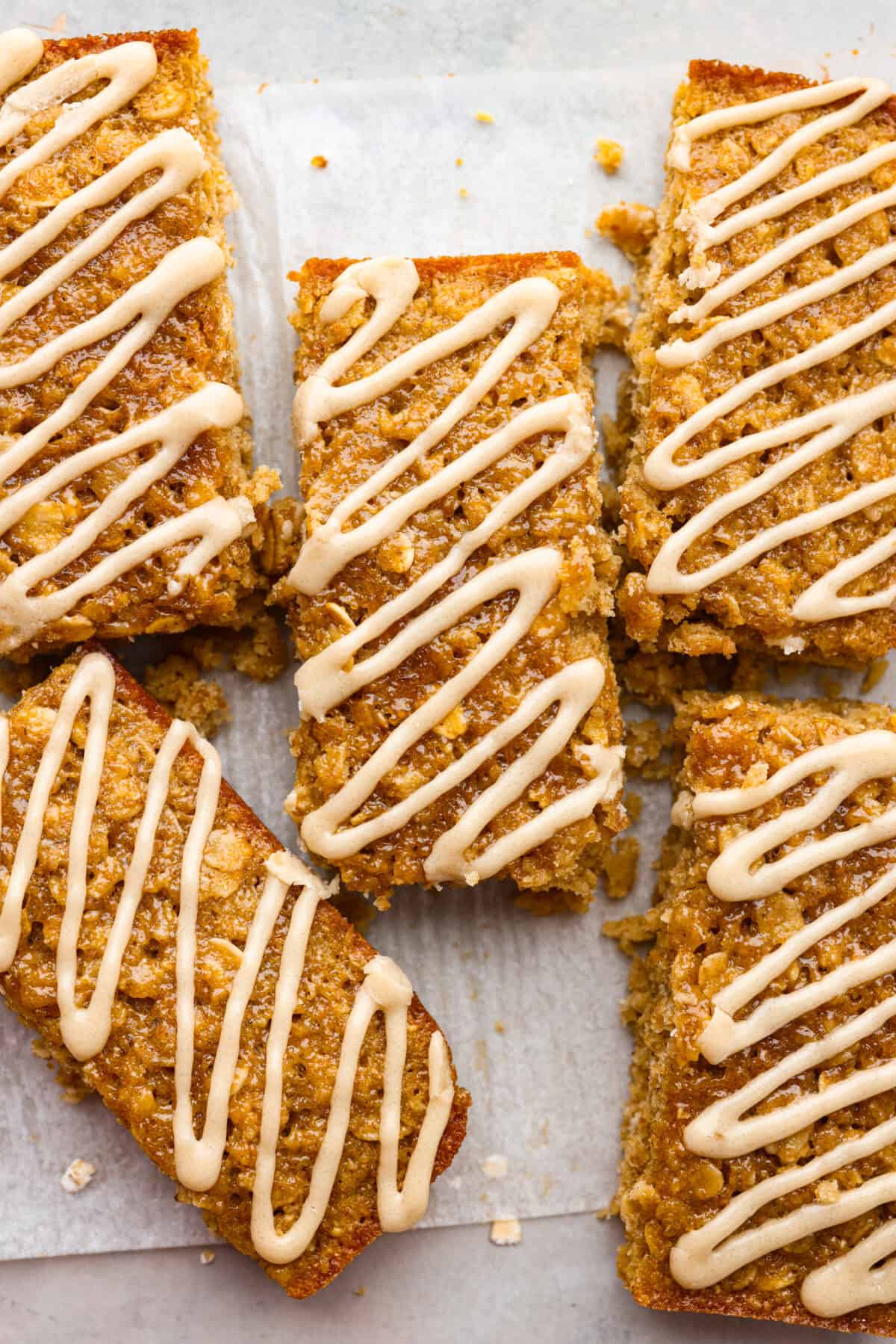 A close up shot of breakfast bars with a glaze drizzled on them. 