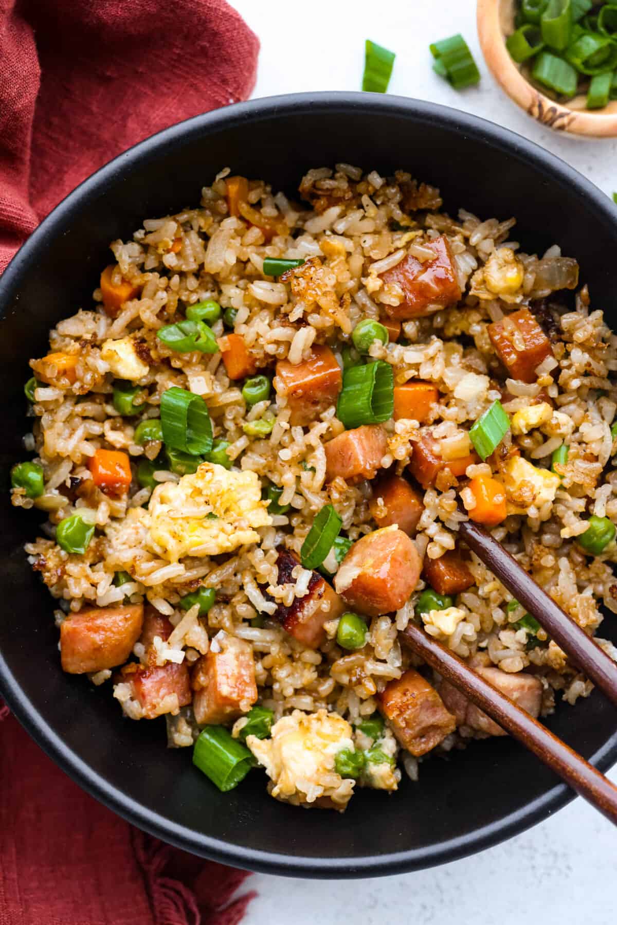 A serving of fried rice in a black bowl.