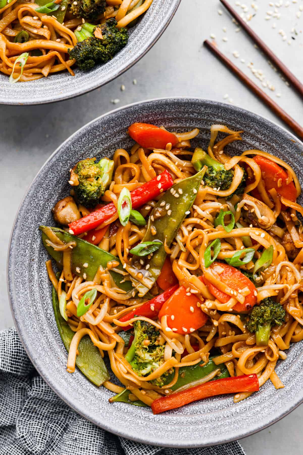 A serving of vegetable lo mein in a gray bowl.