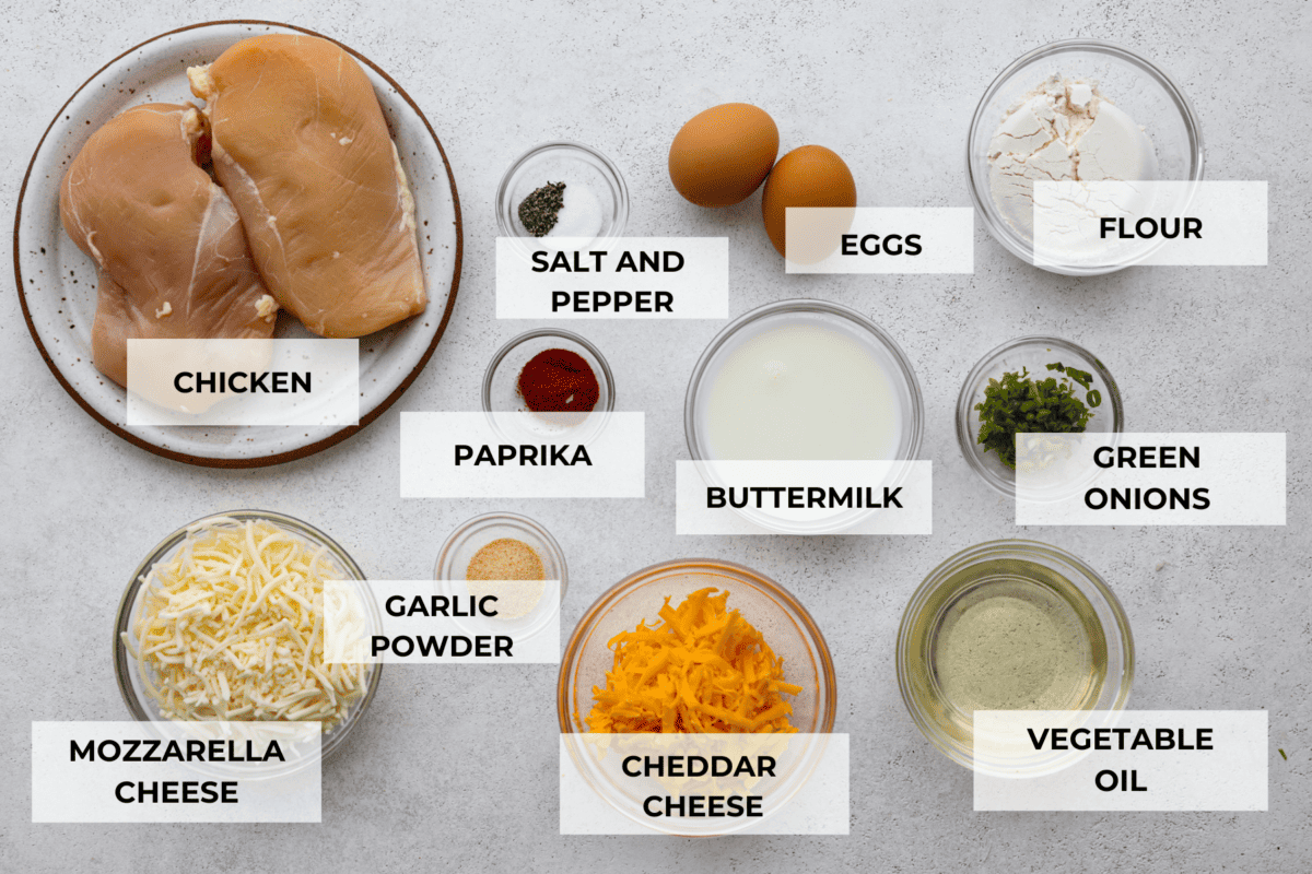 The chicken breasts as well as all of the breading ingredients separated into glass bowls.