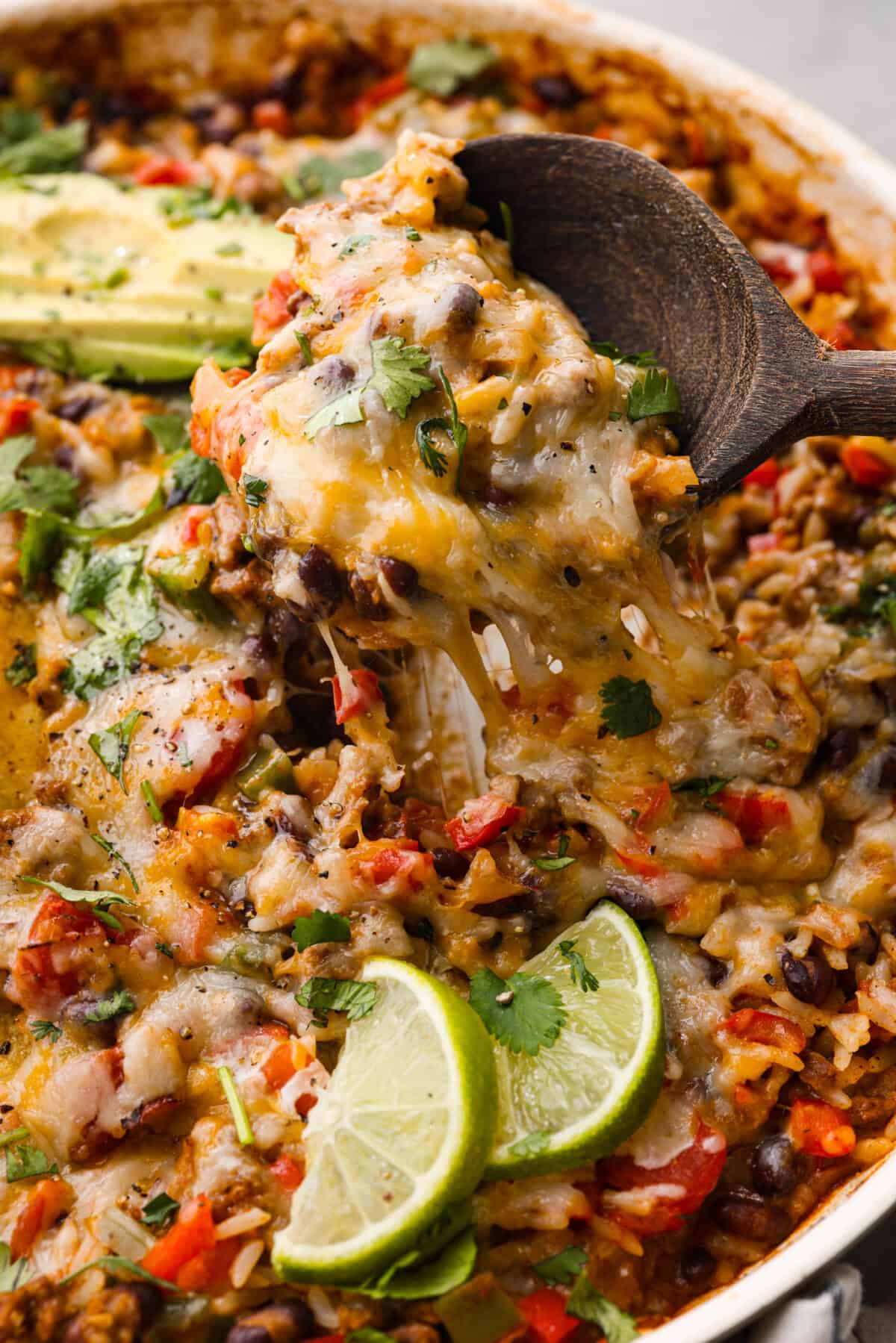 Closeup of a spoonful of cheesy rice, vegetables, and ground beef.