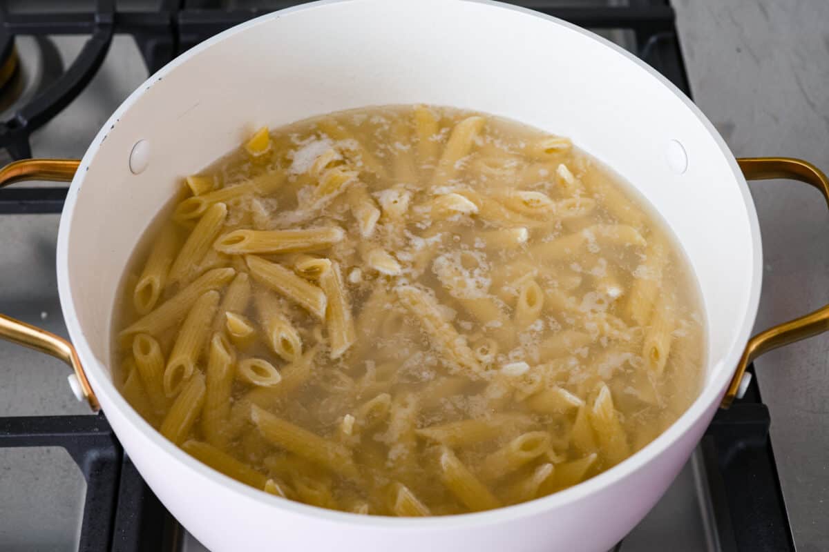 Penne pasta in water in a pot. 