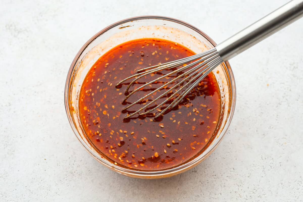 Overhead shot of firecracker sauce with whisk. 