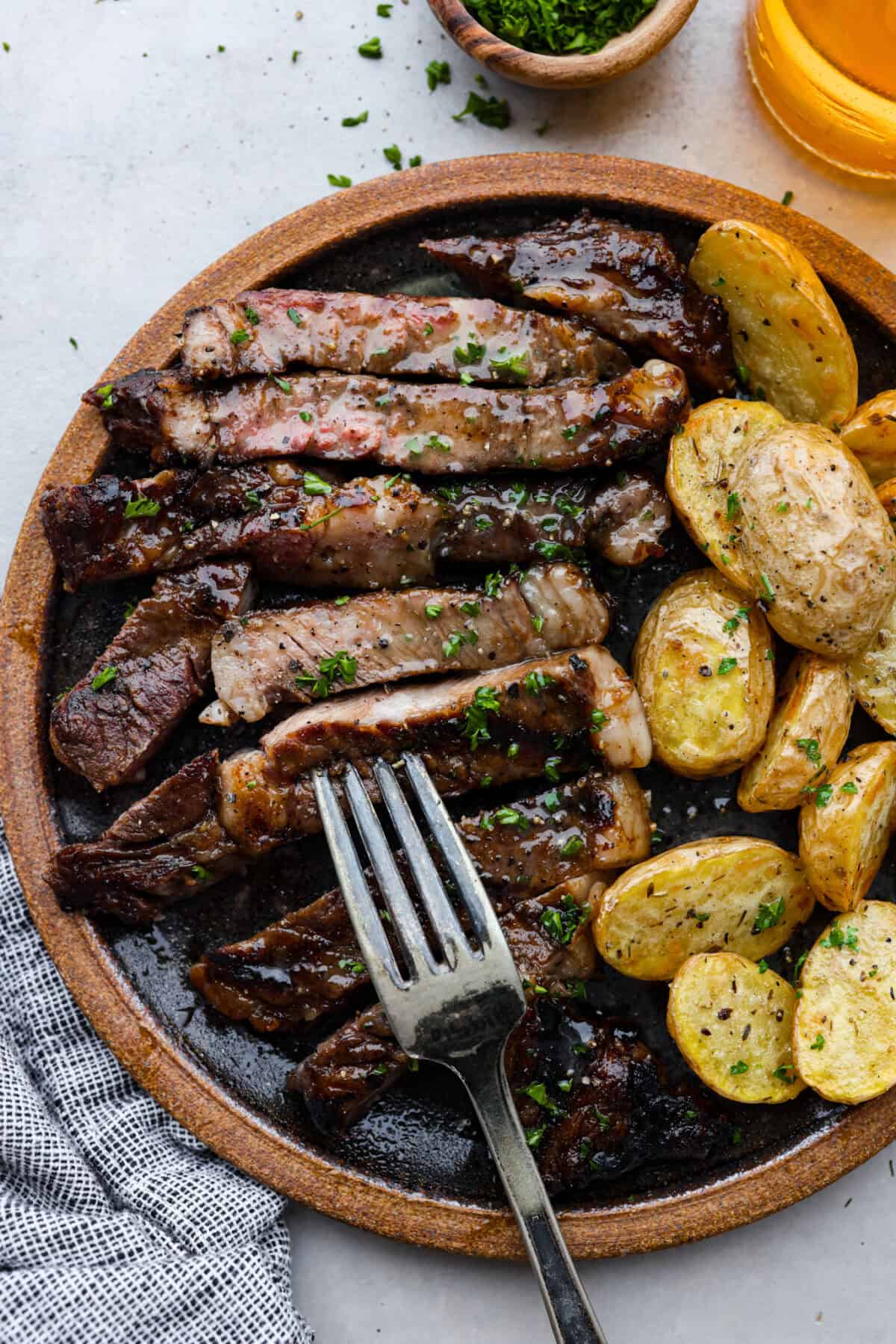 Steak and potatoes on a plate, ready to eat. 