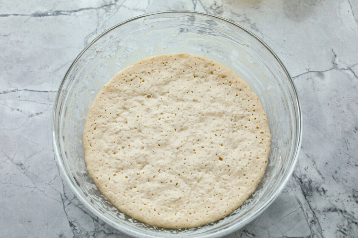 Overhead shot of dough resting in glass bowl 