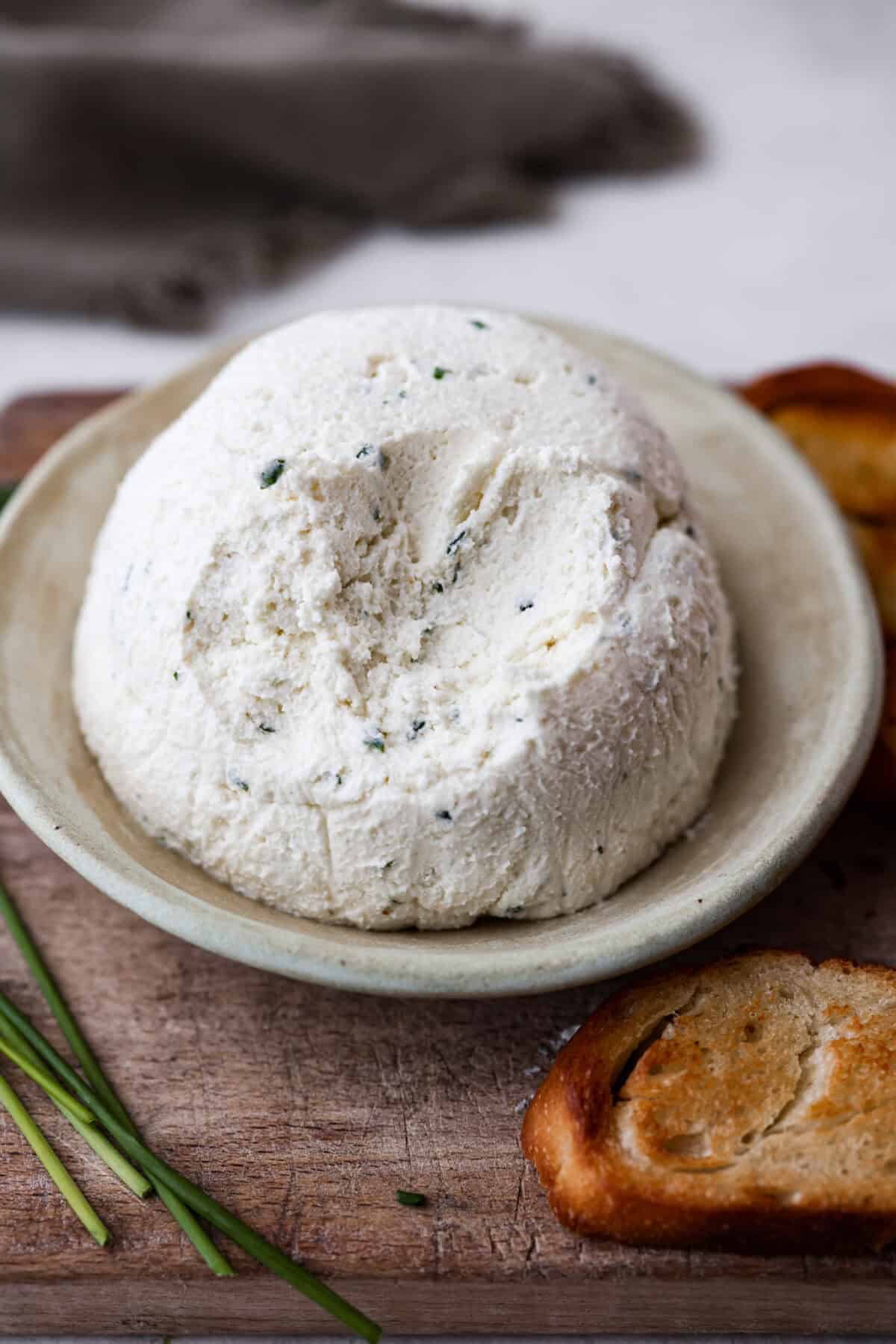 Angle shot of ball of Boursin cheese with some scoops taken out of it. 