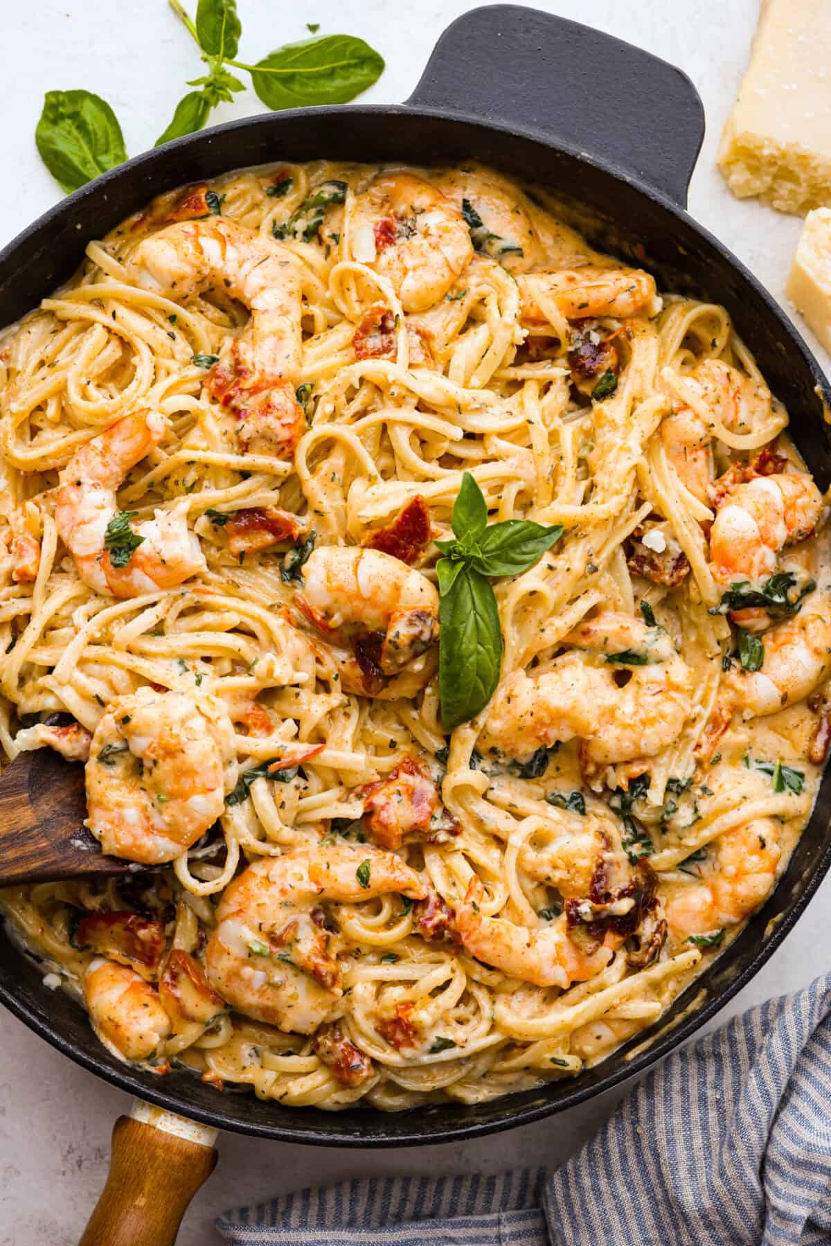 Overhead close up shot of garnished marry me shrimp with pasta dish. 